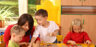 SE NECESITA NIÑERA 30 HORAS SEMANALES, JORNADA DE TRABAJO DE 9:00 A 15:00HS teacher and three preschoolers plazing with wooden blocks